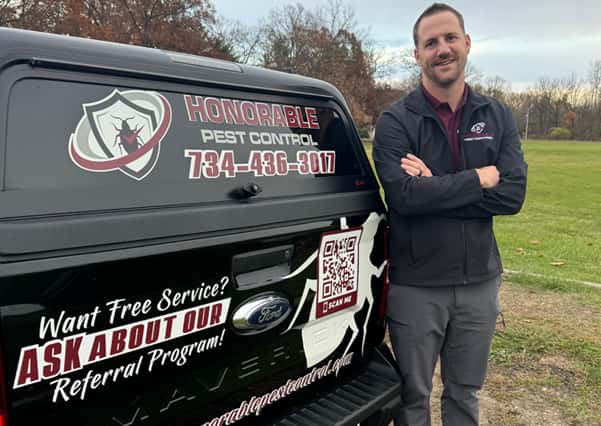Nick Russler, owner of Honorable Pest Control, beside the company vehicle